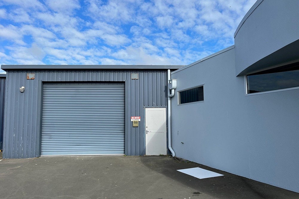 Onekawa Trade Depot with a garage door and a blue sky.