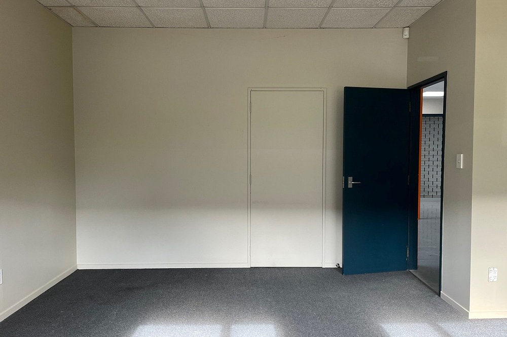 An empty office with a blue door at Onekawa Trade Depot.
