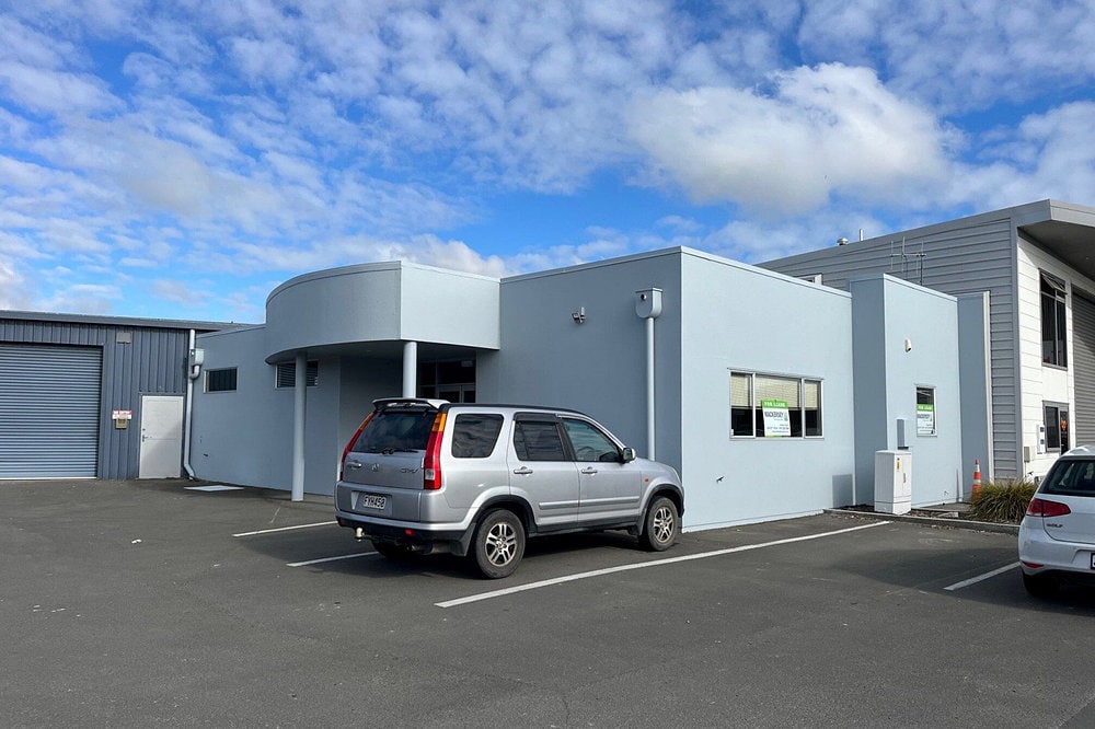 Two cars parked in front of Onekawa Trade Depot.